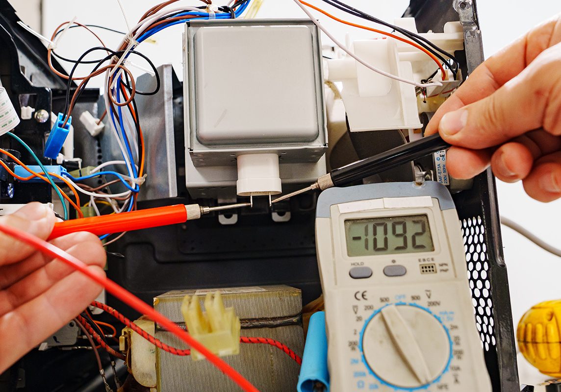 Russia, Rostov-on-Don, 01.10.2022. Diagnostics repair of microwave oven. hands of the master with the probes of the measuring instrument of the multimeter.