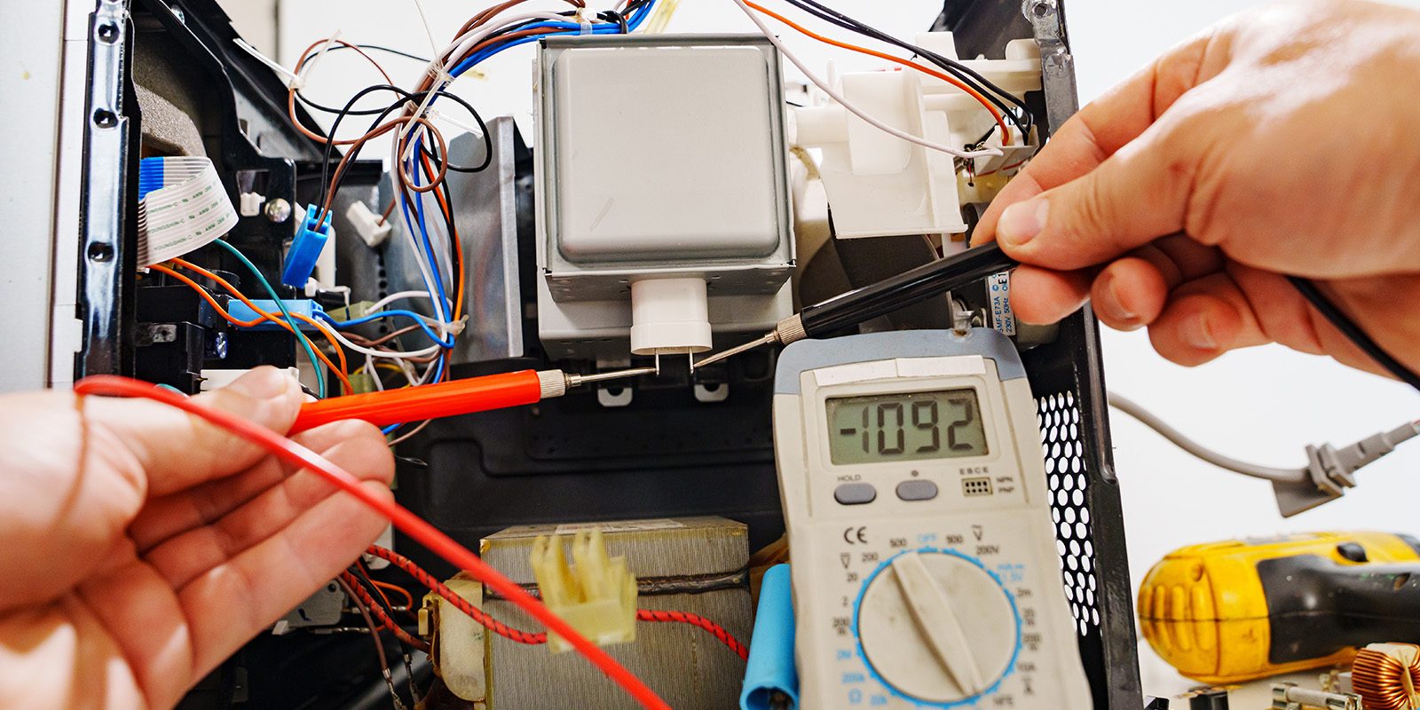 Russia, Rostov-on-Don, 01.10.2022. Diagnostics repair of microwave oven. hands of the master with the probes of the measuring instrument of the multimeter.