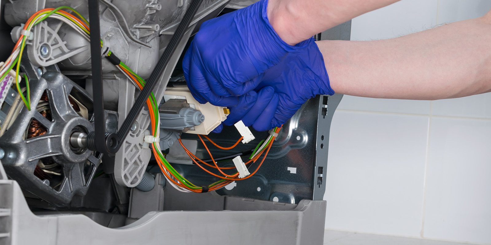 close-up of the installation of the new control unit of the washing machine mechanisms, by the master under warranty